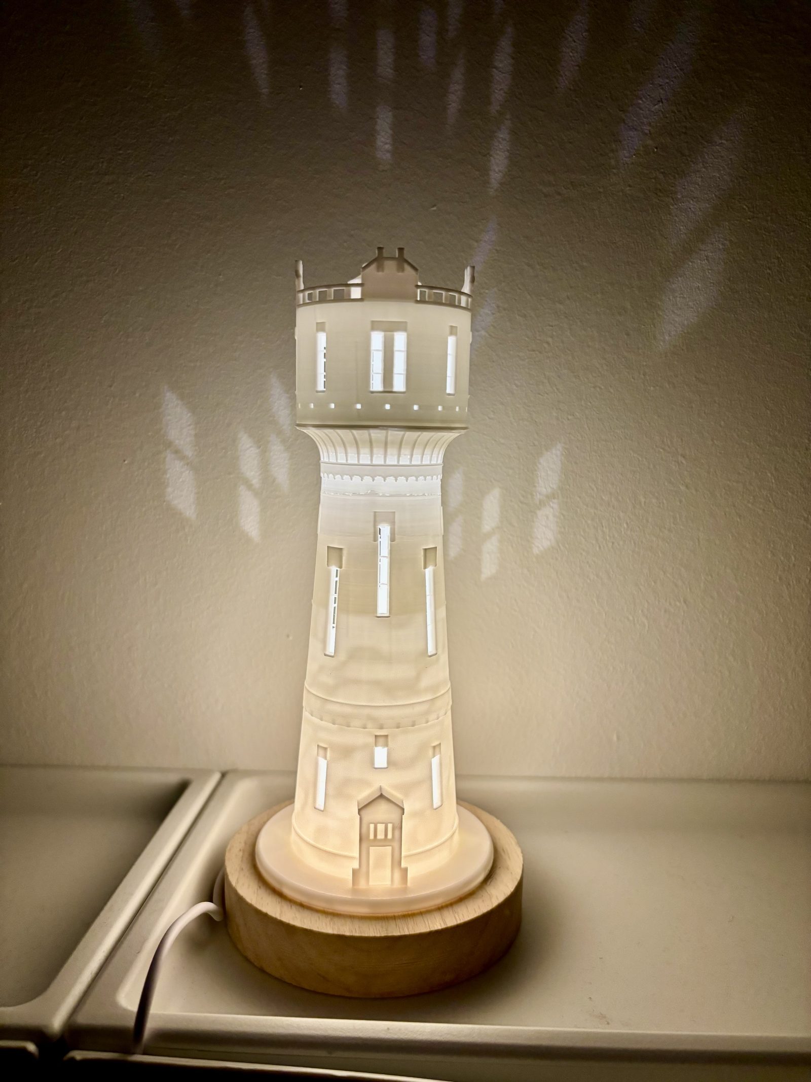 Verlichte 3D-geprinte watertorenlamp op een houten voet